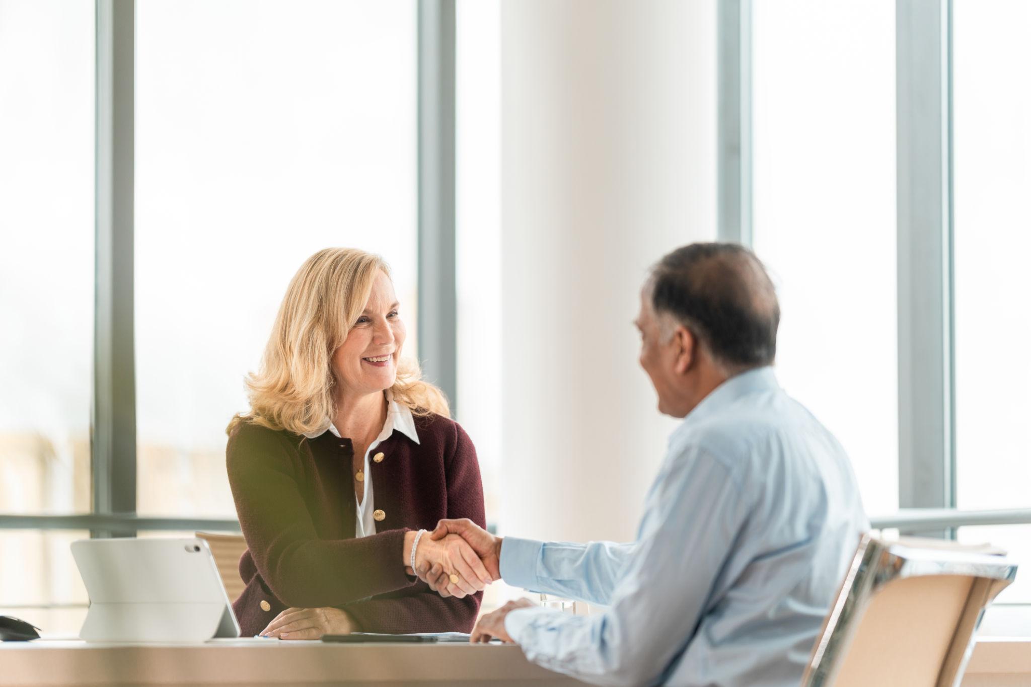 Member shaking hands with a Heritage advisor in a bright office